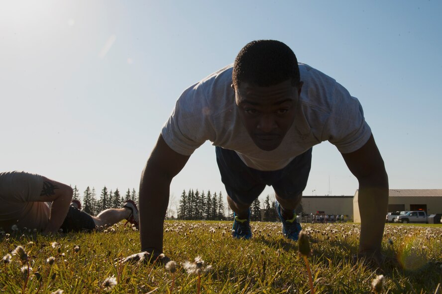 Airman 1st Class Brian Dixon, 5th Security Forces Squadron defender, completes "burpees" during the Security Forces Survivors Challenge on Minot Air Force Base, N.D., May 20, 2015. Airmen completed different exercises for their team and challenged their resiliency and strength in this friendly competition. (U.S. Air Force photo/Airman 1st Class Christian Sullivan)