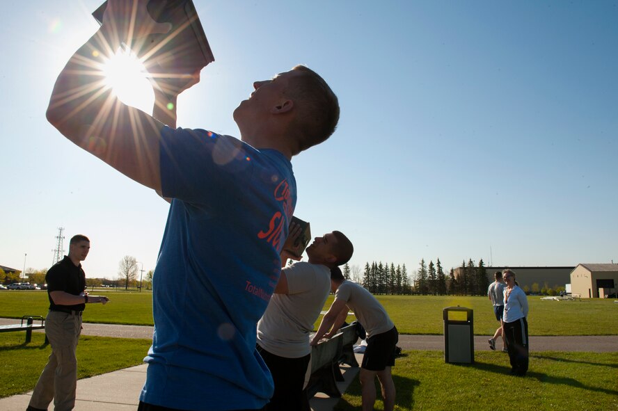 Airman 1st Class Eric Nash, 5th Security Forces Squadron defender, competes in the Security Forces Survivors Challenge as he pushes a heavy ammo box above his head on Minot Air Force Base, N.D., May 20, 2015. Airmen challenged their resiliency and strength in this friendly competition. (U.S. Air Force photo/Airman 1st Class Christian Sullivan)