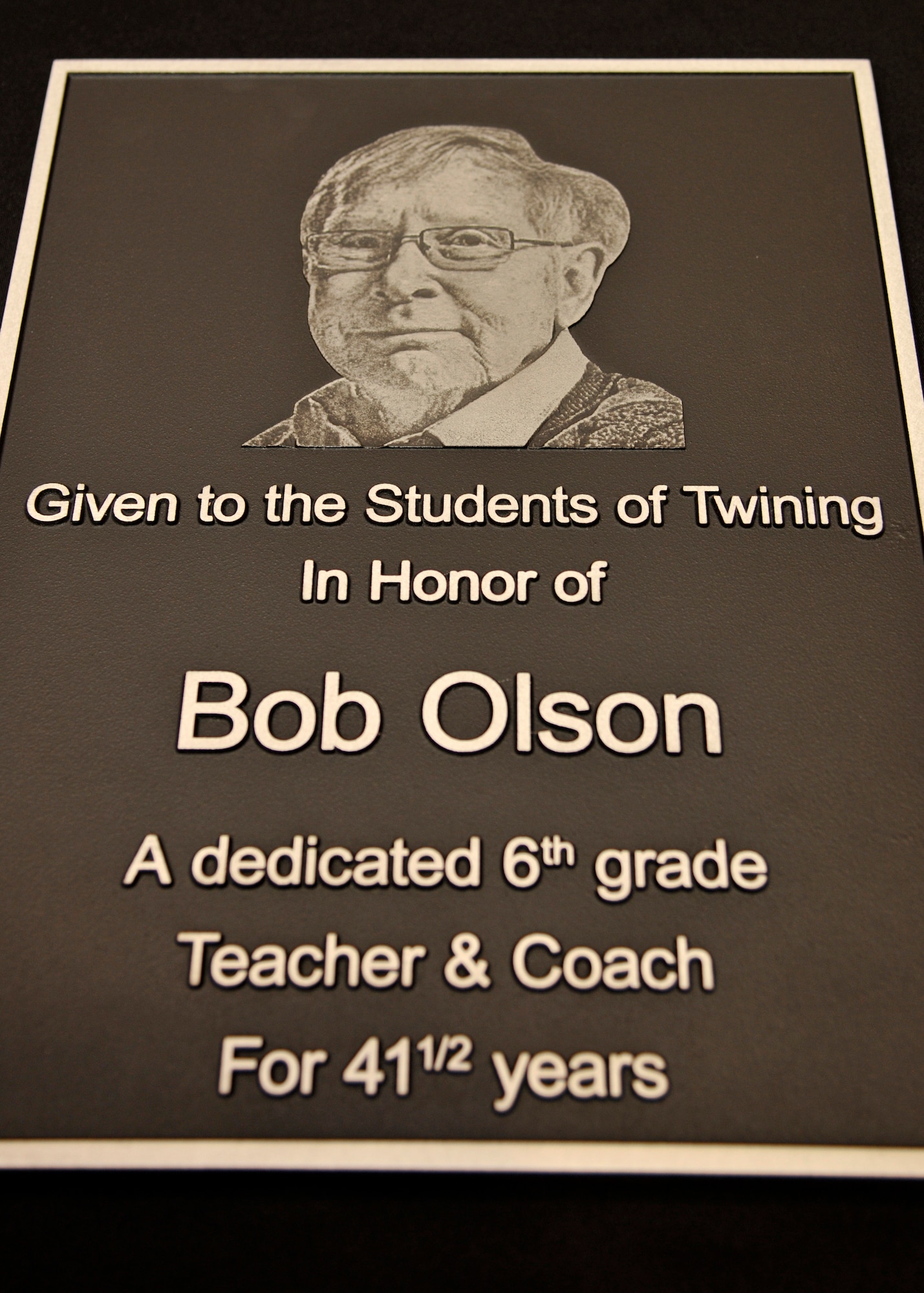 A plaque remembering Robert “Bob” Olson, teacher and coach at Nathan F. Twining Elementary and Middle School, was dedicated on May 18, 2015, on Grand Forks Air Force Base, N.D. Olson joined the Army Reserves in 1963 and after, he started teaching students and coached seventh and eighth grade football and track. Olson passed away on Oct. 15, 2014 at the age of 69 while battling prostate cancer.  (U.S. Air Force photo by Senior Airman Xavier Navarro/released)
