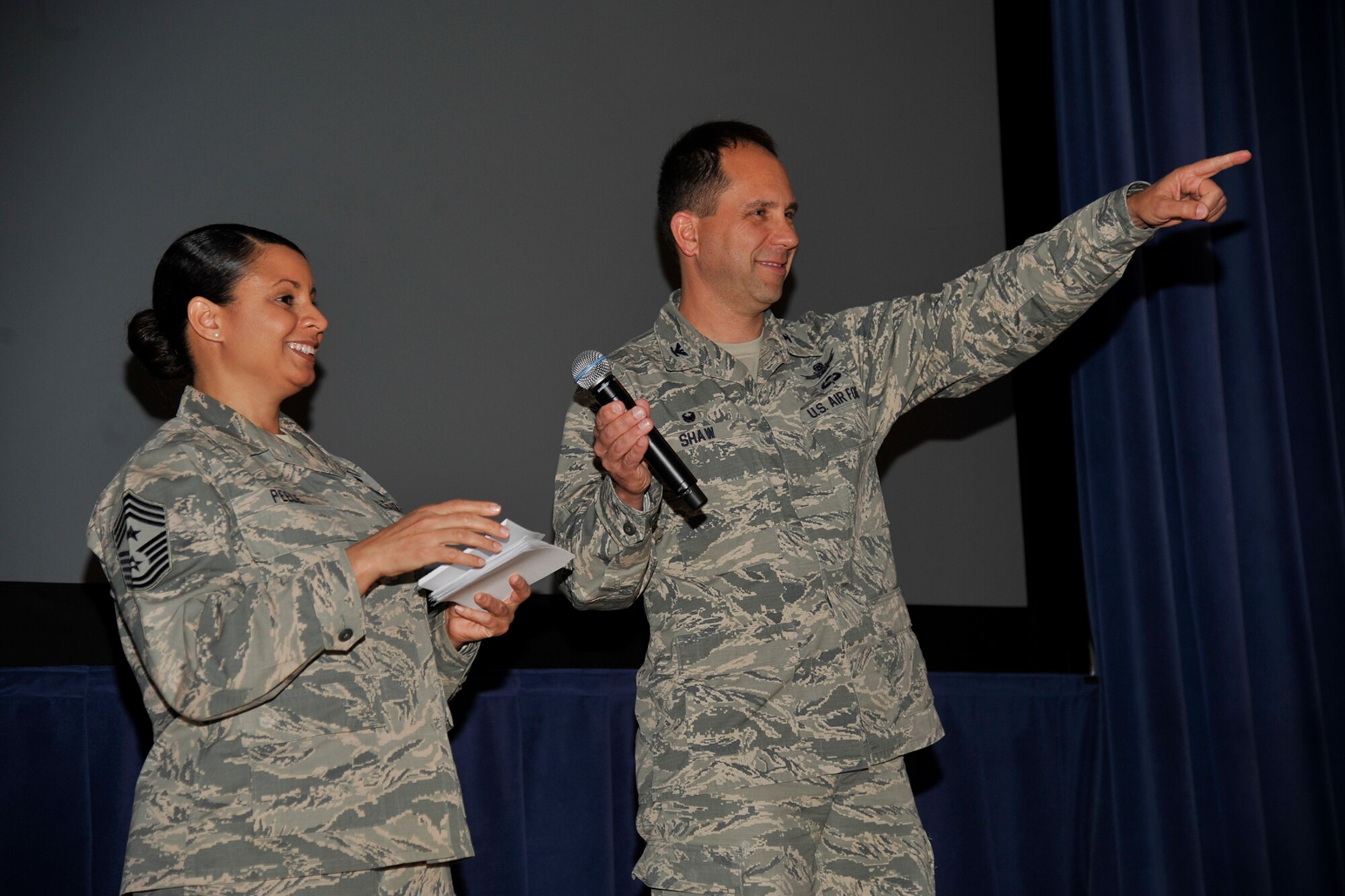 PETERSON AIR FORCE BASE, Colorado – Col. John Shaw, 21st Space Wing commander, and Chief Master Sgt. Idalia Peele, 21st SW command chief, announce the results of the 21st Space Wing unit effectiveness inspection May 19, 2015 at the base auditorium. The wing scored an “Effective” rating during the inspection. (U.S. Air Force photo by Robb Lingley)