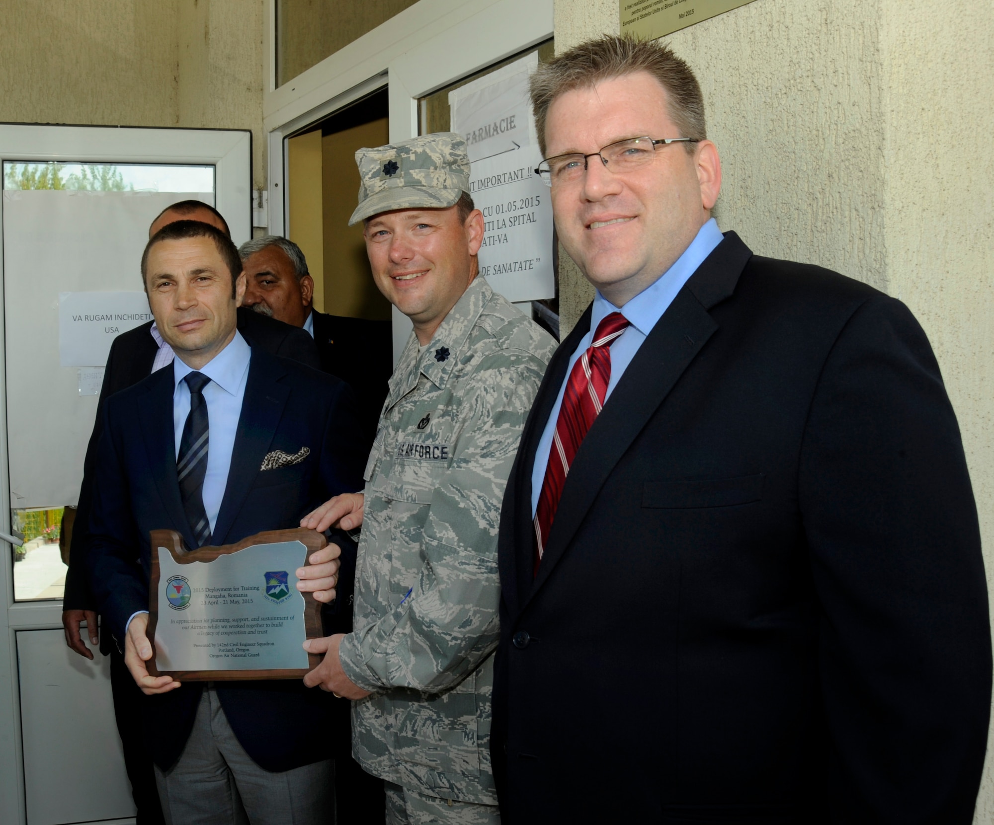 U.S. Charge d’Affairs a.i., Dean Thompson, right, along with and Mayor of Mangalia, Romania, Radu Cristian, left, pause for a photograph with Lt. Col. Jason Lay, 142nd Fighter Wing Civil Engineer Squadron, center, as he presents a plaque to the Mayor, after the ribbon cutting of the renovated Pavilion C of the Mangalia City Hospital, Romania, May 20, 2015, as part of the U.S. European Command’s (EUCOM) Humanitarian Civic Assistance Program (HCA). The EUCOM HCA program is designed to improve the host nation's critical infrastructure and the underlying living conditions of the civilian populace. (U.S. Air National Guard photo by Tech. Sgt. John Hughel, 142nd Fighter Wing Public Affairs/Released)