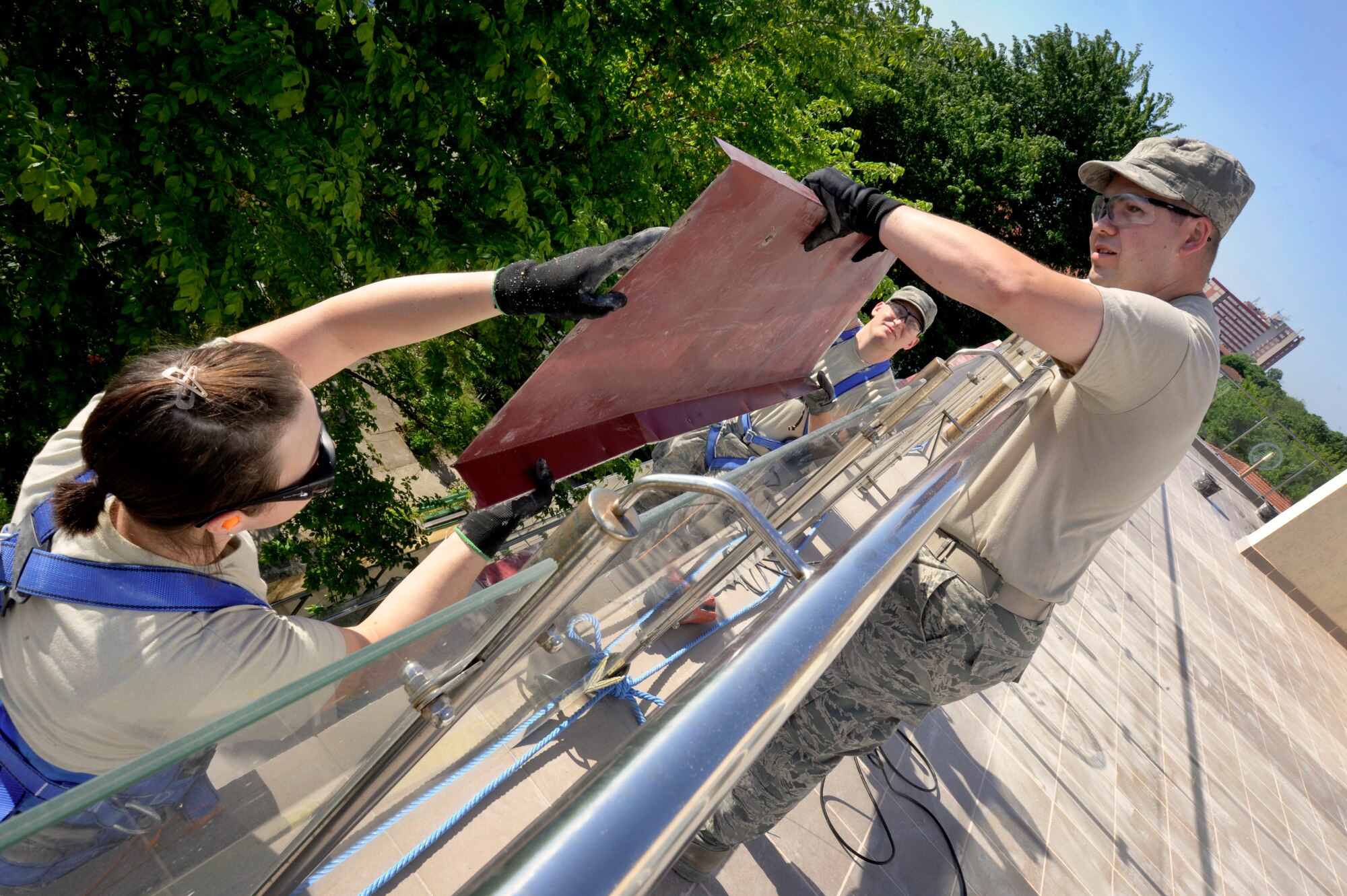 Oregon Air National Guard Tech Sgt. Adrian Tate, right, along with Staff Sgt. Samantha Orem, left, and Senior Airman Devin, Sheehan, center, assigned to the 142nd Fighter Wing Civil Engineers Squadron, install flashing sections reinstalled to a health clinic in the city of Mangalia, Romania, May 14, 2015, as part of the U.S. European Command’s (EUCOM) Humanitarian Civic Assistance Program (HCA). The EUCOM HCA program is designed to improve the host nation's critical infrastructure and the underlying living conditions of the civilian populace. (U.S. Air National Guard photo by Tech Sgt. John Hughel, 142nd Fighter Wing Public Affairs/Released)