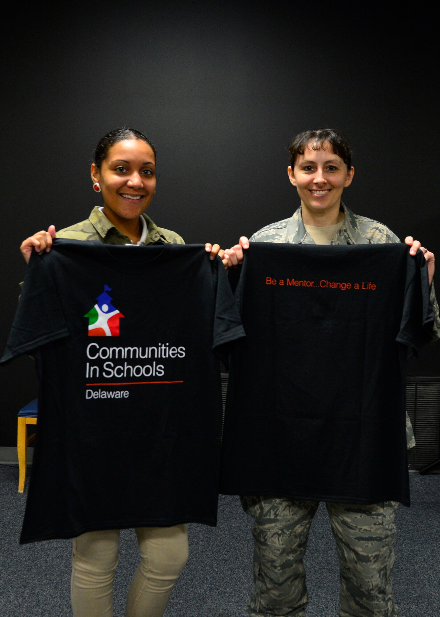 Isis  Potts, Milford High School 9th Grader, left, poses for a photo with her mentor Senior Master Sgt. Shannon Lee, 436th Force Support Squadron career assistance advisor, while holding their Communities In Schools program shirts May 21, 2015, at Eagle Lanes Bowling Alley on Dover Air Force Base, Del. CIS established their second PHASE, or Professionals Helping Adolescents Succeed in Education program, in the nation with Team Dover. (U.S. Air Force photo/Airman 1st Class William Johnson)