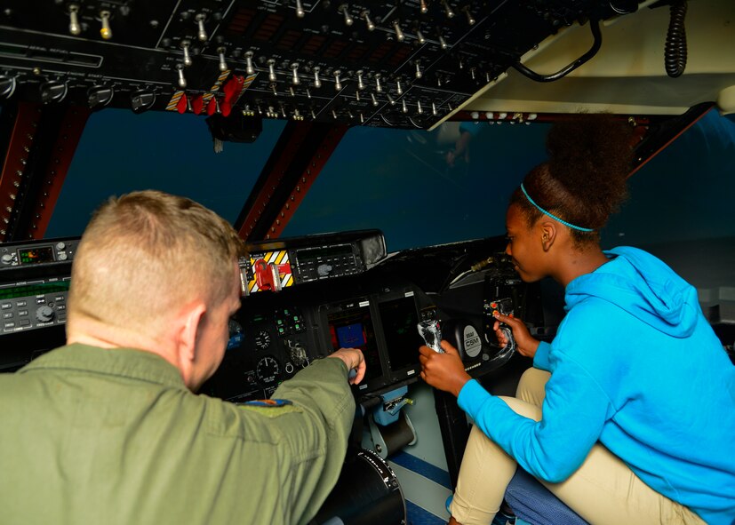Master Sgt. Marc Gonsalves, 9th Airlift Squadron assistant loadmaster superintendent, shows how a multi-function display works to his mentee, Kalaysia Reynolds, Milford High School 11th Grader, inside of a C-5M Super Galaxy simulator May 21, 2015, at Dover Air Force Base, Del. The simulator is the same simulator that C-5 pilots train on. (U.S. Air Force photo/Airman 1st Class William Johnson)