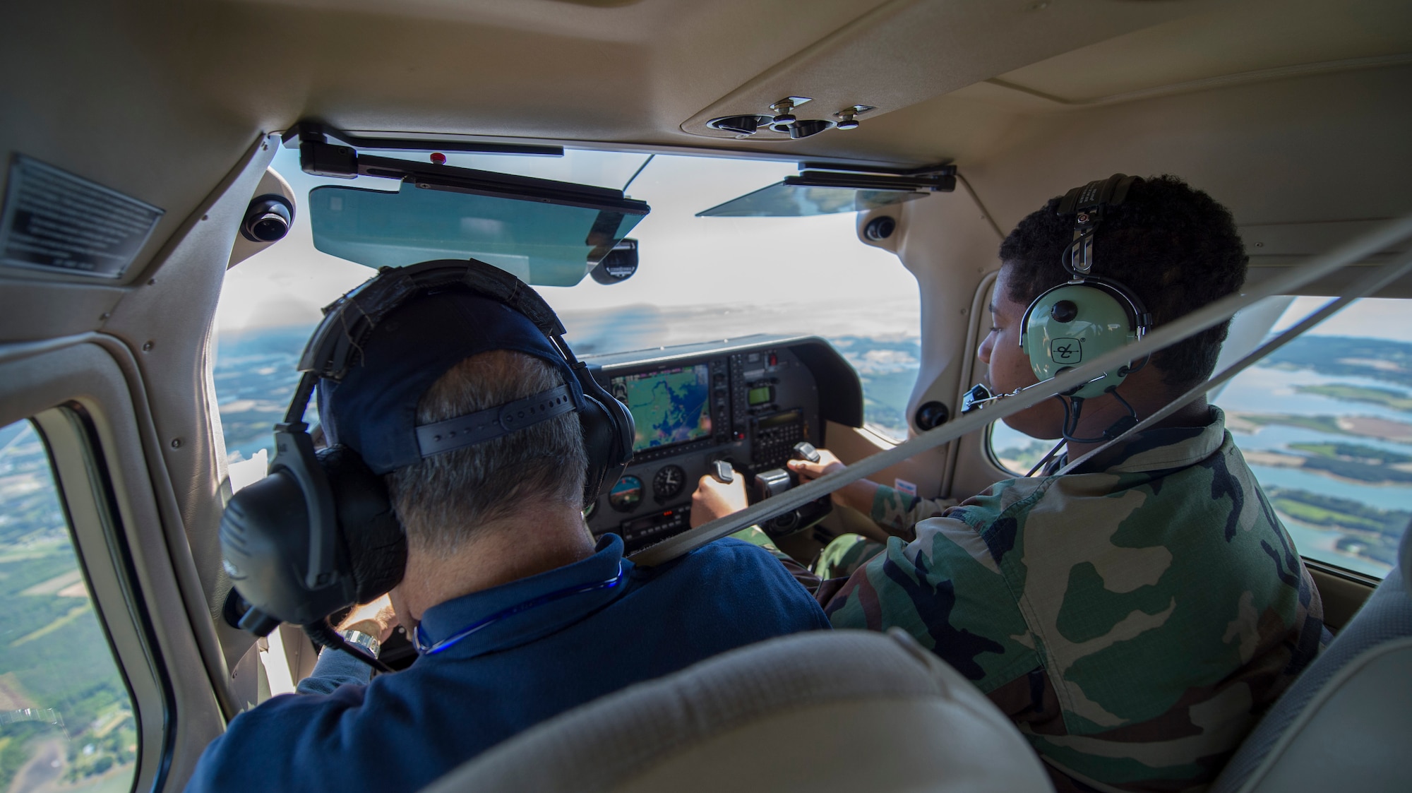 Rick Micker, left, Congressional Squadron member, Civil Air Patrol, allows Cadet Keon Gilchrist, Andrews Composite Squadron, to fly the aircraft during a cadet orientation flight from Joint Base Andrews, Md., to Cambridge-Dorchester Airport, Md., May 23, 2015. This was Gilchrist’s first time flying an aircraft. (U.S. Air Force photo/Airman 1st Class Ryan J. Sonnier)
