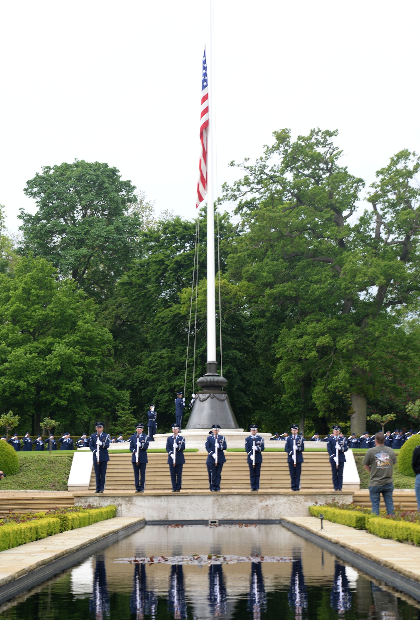 RAF Midenhall base honor guard salute the raising flag concluding the annual Memorial Day ceremony at the Cambridge American Cemetery and Memorial May 25, 2015, in Cambridge, England. The honor guard also performed a three-volley salute during the service in remembrance of the fallen heroes. (U.S. Air Force photo by Senior Airman Kate Thornton/Released)