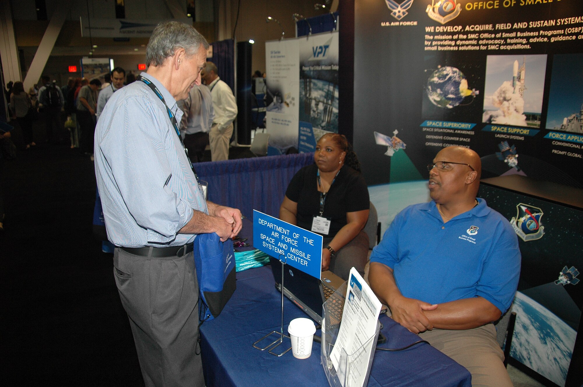 Willard Strozier, director, and Audrey Campbell, deputy director, of the Office of Small Business Programs from Space and Missile Systems Center at Los Angeles Air Force Base in El Segundo, Calif., talk with an attendee at the 2015 Space Tech Conference and Expo held at the Long Beach Convention Center May 19-21. More than 3,500 registered attendees and 200 exhibitors, including SMC participated in the three-day event. (U.S. Air Force photo/Jim Spellman)