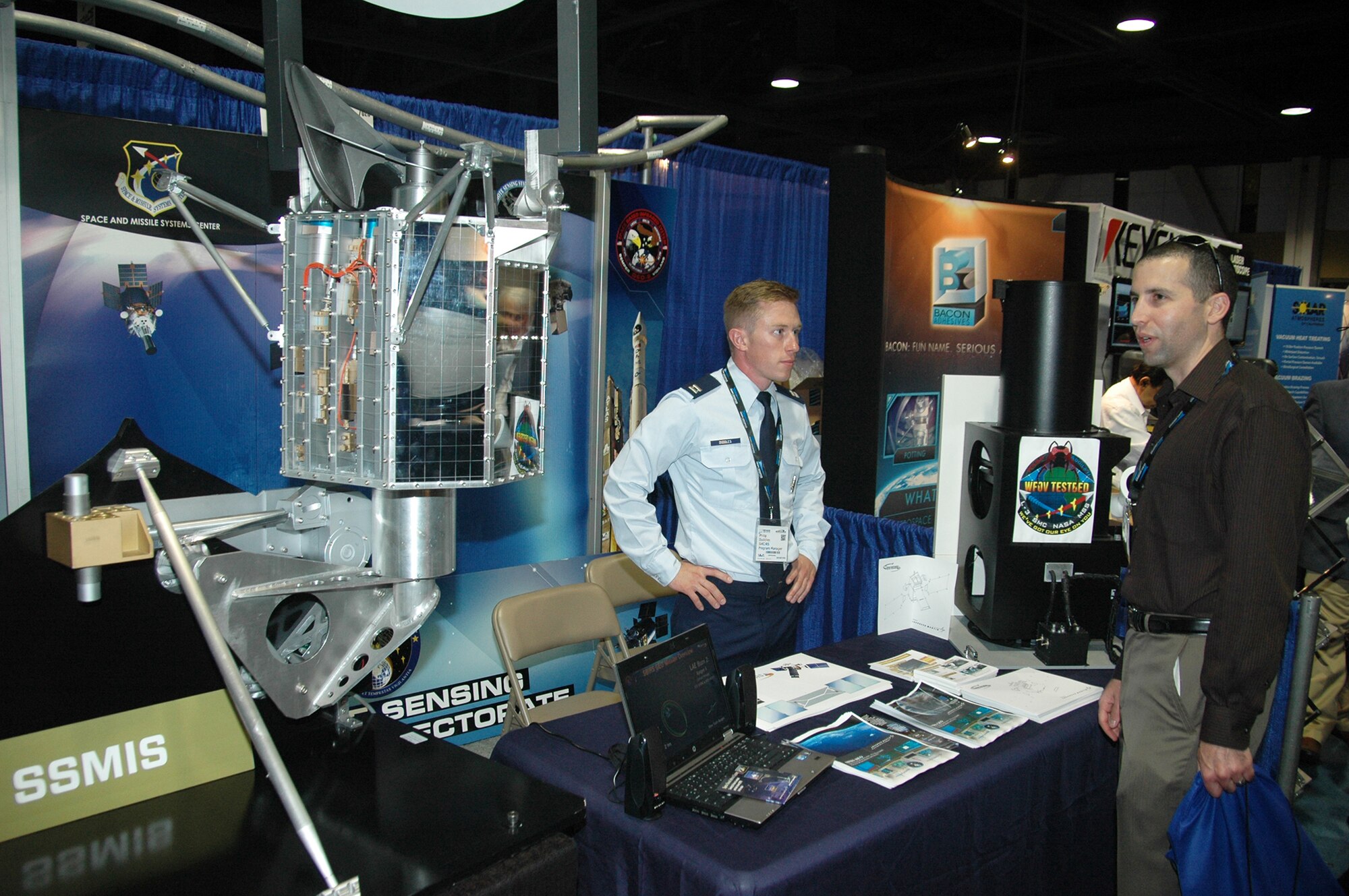 Capt. Philip Duddles, Remote Sensing Program Manager, from the Space and Missile Systems Center at Los Angeles Air Force Base in El Segundo, Calif., converses with an attendee at the 2015 Space Tech Conference and Expo at the Long Beach Convention Center May 19. More than 3,500 registered attendees and 200 exhibitors including SMC attended the three-day event. (U.S. Air Force photo / Jim Spellman) 