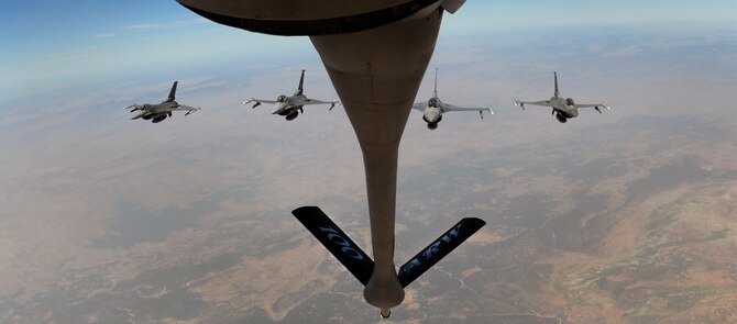 A four ship F-16 Fighting Falcon formation from Spangdahlem Air Base, Germany, flies behind a KC-135 Stratotanker assigned to RAF Mildenhall, England, while participating in Exercise African Lion May 18, 2015. The exercise features first-time integrated flying operations training and is the largest Department of Defense exercise in Africa. (U.S. Air Force photo by Senior Airman Victoria H. Taylor/Released)