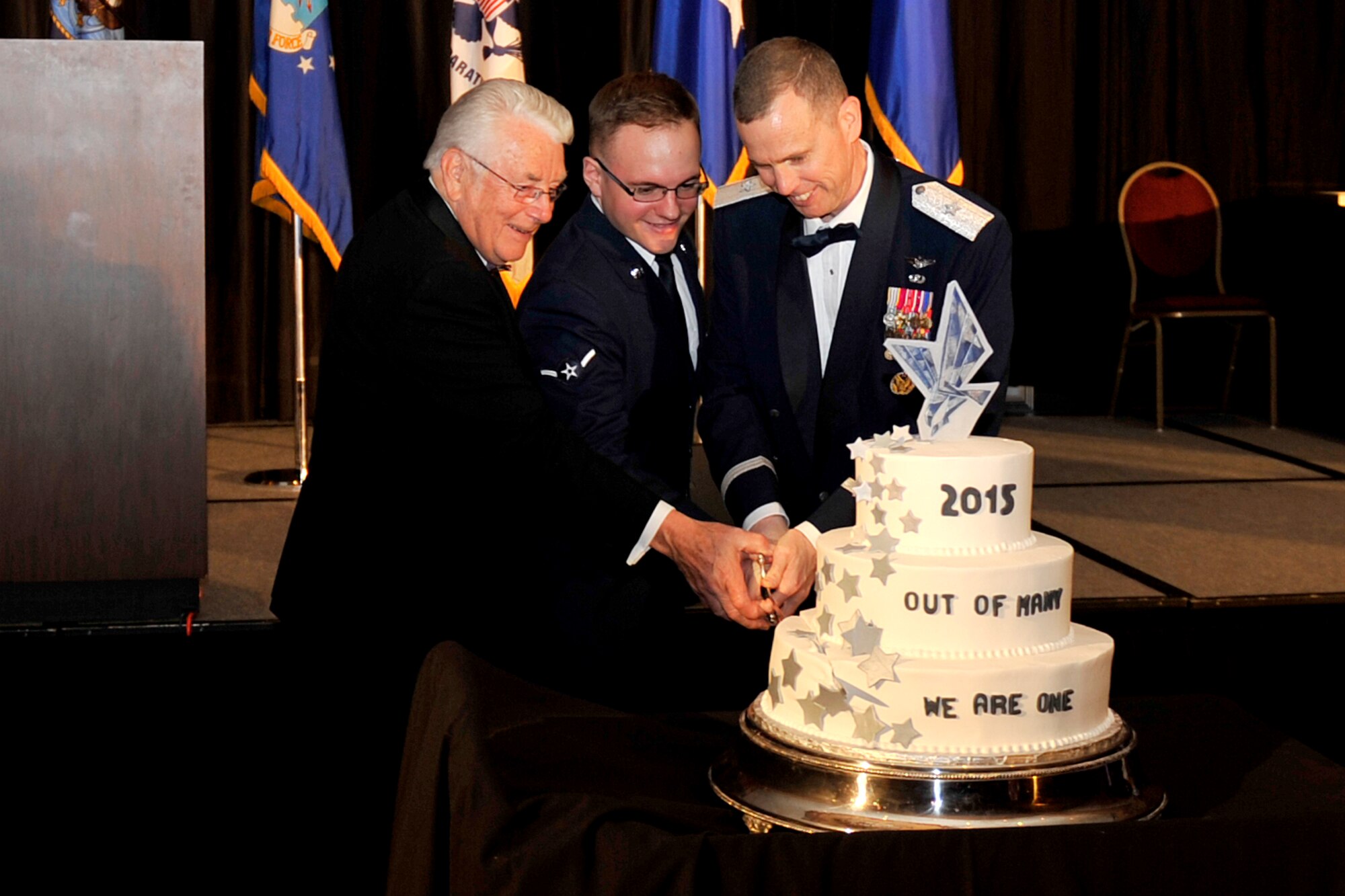 (from left to right) U. S. Air Force Col. (Ret.) Bill Ernst, the senior representative with the newest member of the 55th Wing, U.S. Air Force Airman Dylan Gabel, 55th Force Support Squadron and U.S. Air Force Brig. Gen. Gregory M. Guillot, 55th Wing commander, perform the ceremonial cutting of the cake at the 2015 55th Wing Birthday Ball.  The birthday ball was held at the Embassy Suites in La Vista, Nebraska on May 16. Attendees gathered to honor the wing’s past and celebrate the current role of the Fightin’ Fifty-Fifth in today’s Air Force. (U.S. Air Force photo by Jeff W. Gates/Released)