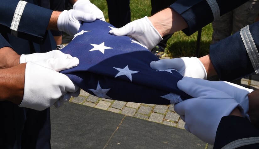U.S. Air Force Honor Guardsmen hold a flag during flag folding ceremony in honor of Capt. Glenn Cook in front of the Vietnam Veteran’s Memorial in Washington, D.C., May 19, 2015. Cook’s plane was shot down near Nha Trang, Vietnam, Oct. 21, 1969. His remains were never found. (U.S. Air Force photo/Senior Airman Joshua R. M. Dewberry)