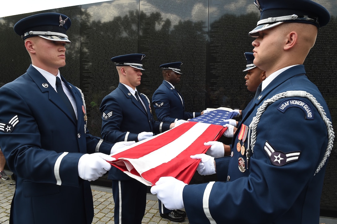 U.S. Air Force Honor Guardsmen perform a flag folding ceremony in honor of Capt. Glenn Cook, in front of the Vietnam Veteran’s Memorial in Washington, D.C., May 19, 2015. Cook’s plane was shot down near Nha Trang, Vietnam, Oct. 21, 1969. His remains were never found. (U.S. Air Force photo/Senior Airman Joshua R. M. Dewberry)