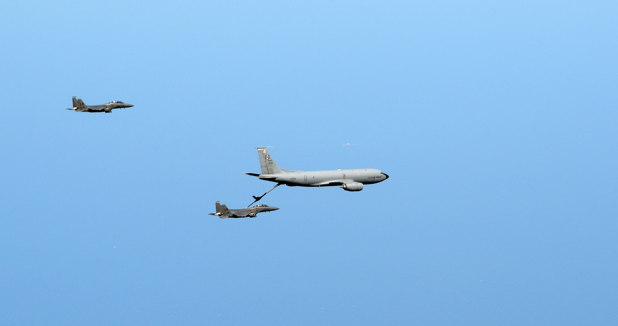 A U.S. Air Force KC-135 Stratotanker assigned to RAF Mildenhall, England, refuels two F-15E Strike Eagles assigned to RAF Lakenheath, England May 12, 2015, over England. Refueling took place for routine training. (U.S. Air Force photo by Senior Airman Christine Halan/Released)