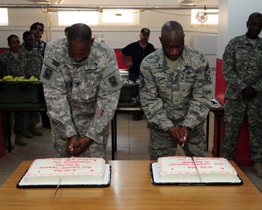 Command Sgt. Maj. Eric McCray, 5th Battalion, 52nd Air Defense Artillery Battalion and Chief Master Sgt. Vegas Clark, 39th Air Base Wing command chief, cut cakes after an NCO Induction Ceremony May 21, 2015, at Gaziantep, Turkey. (U.S. Air Force photo by Staff Sgt. Caleb Pierce/Released)