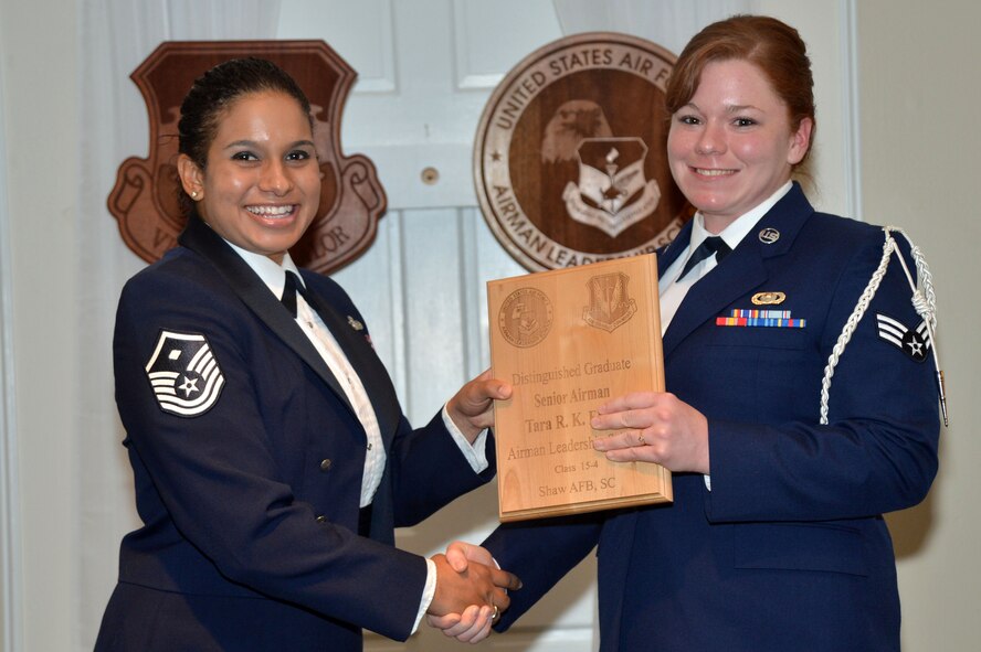 U.S. Air Force Senior Airman Tara Elben, 31st Intelligence Squadron, receives a distinguished graduate award for the Senior Master Sgt. David B. Reid Airman Leadership School Class 15-4 from Master Sgt. Lee Hanna Mendoza, 20th Logistics Readiness Squadron, at Shaw Air Force Base, S.C., May 21, 2014. The distinguished graduate awards are given to the top 10 percent of the class for total point accumulation. (U.S. Air Force photo by Airman 1st Class Michael Cossaboom/Released)