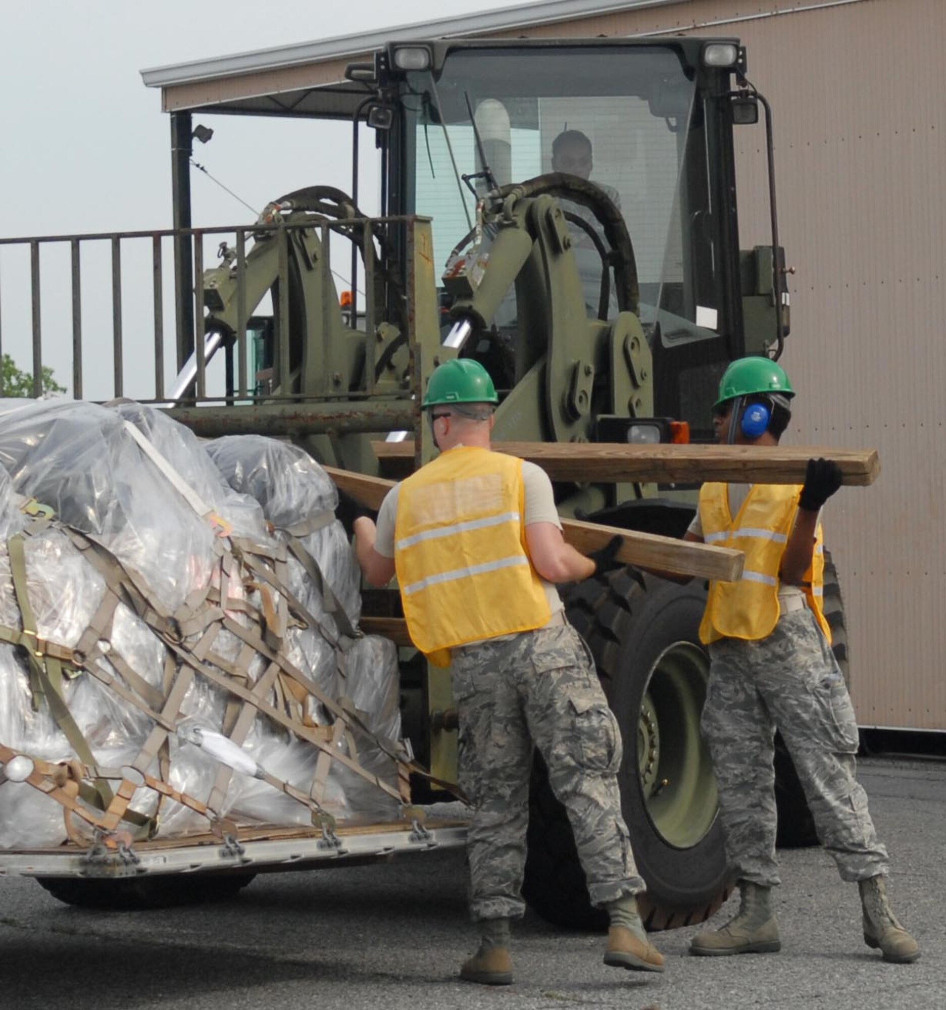 Airmen place dunnage on a 10K Forklift for transport along with a pallet that will be loaded
onto one of the M-1078 vehicles (a 2.5-ton truck). Whether placed on the ground or on a truck bed, the pallets must always sit on three pieces of dunnage, May 14, 2015. (U.S. Air Force photo by Misuzu Allen)