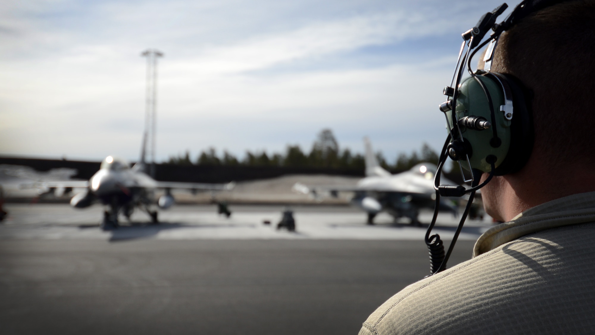 A U.S. Air Force Airman with the 31st Aircraft Maintenance Squadron watches several F-16 Fighting Falcons from Aviano Air Base, Italy, take off from Kallax Air Base, Sweden, May 25, 2015, during Arctic Challenge Exercise 2015. Throughout the duration of the exercise, U.S., NATO and Partners for Peace militaries will work in a joint environment to deliver unified responses for simulated contingencies. ACE 15 is scheduled to continue until June 5, before concluding with its final air operations. (U.S. Air Force photo by Staff Sgt. Evelyn Chavez)