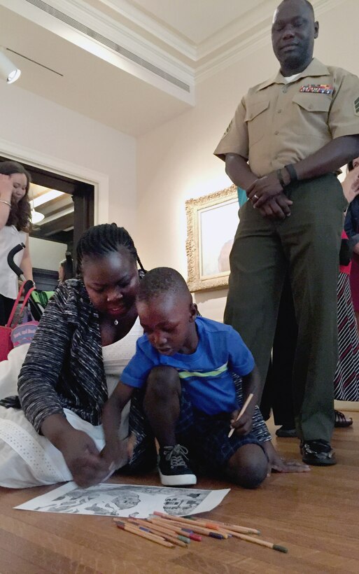 Patricia Ochan colors a black-and-white picture of Vincent van Gogh's "The Road Menders" with her son, William, 4, while her husband, Marine Corps Sgt. Jimmy Ochan, stationed at Indian Head, Md., looks on during a Blue Star Museum event at the Phillips Collection in Washington, May 20, 2015. DoD photo by Shannon Collins