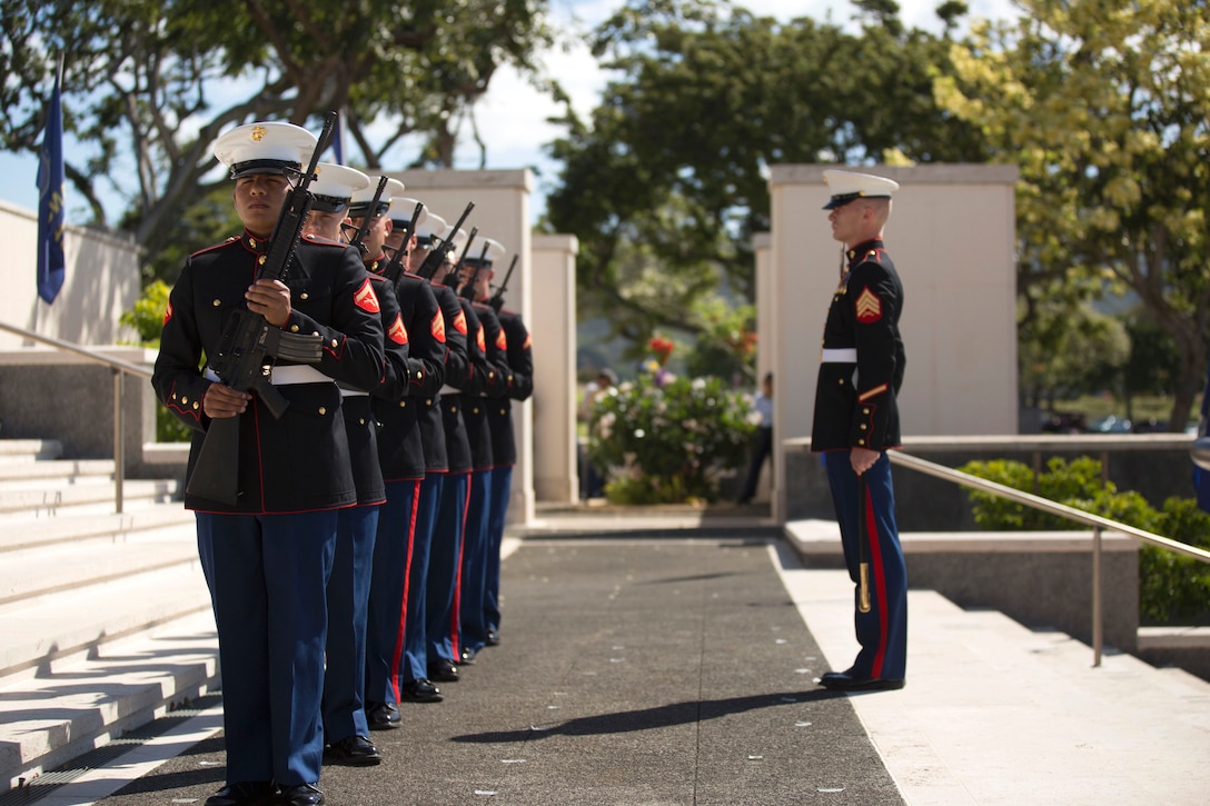 A Marine Corps Honor Guard holds its rifles at port arms, before a three-volley salute during