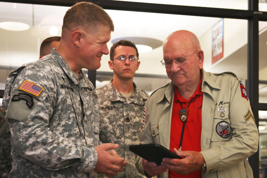 Army Chaplain (Lt. Col.) Brad Baumann, left, presents a gift to retired Army Command Sgt. Maj. Kenneth “Rock” Merritt at the All American Week Prayer Breakfast on Fort Bragg, N.C., May 19, 2015. During his time with the 82nd Airborne Division during World War II, Merritt jumped into Normandy and participated in Operation Market Garden, and fought in the Battle of the Bulge.