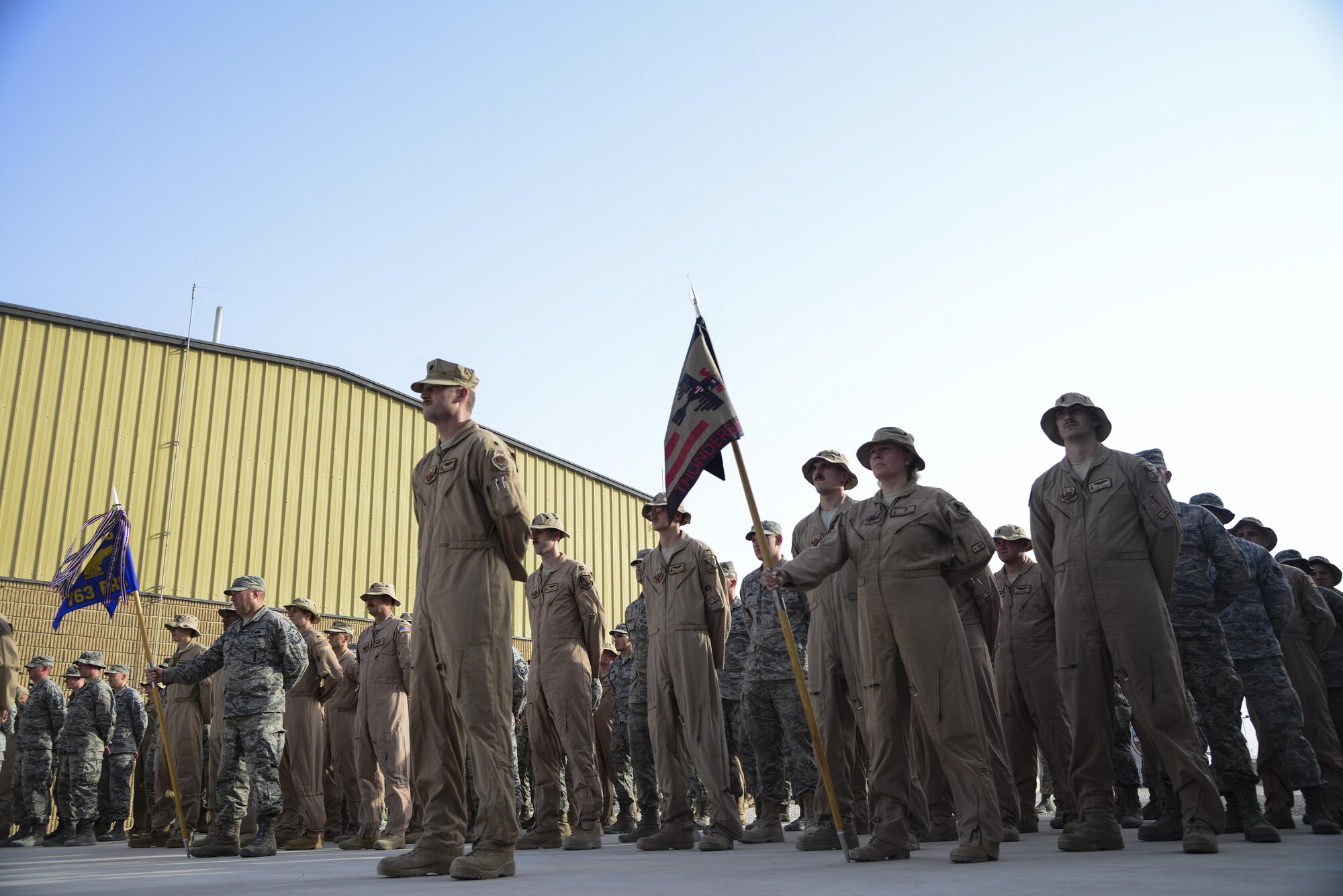U.S. Air Force Airmen assigned to the 379th Expeditionary Operations Group stand at parade rest as they await Taps to play at Memorial Plaza May 25, 2015, at Al Udeid Air Base, Qatar. The group was part of a retreat ceremony for Memorial Day, saluting the Service members that paid the ultimate sacrifice for our country. (U.S. Air Force photo by Tech. Sgt. Rasheen Douglas)