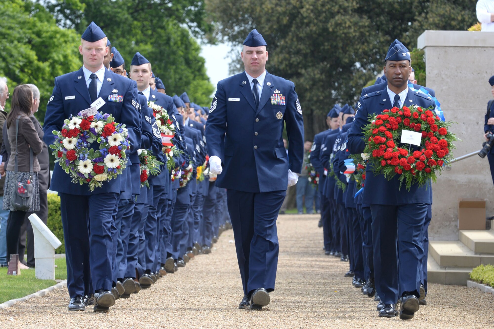 U.S. Air Force Airmen march into position with their respective wreaths during the annual Memorial Day observance at the Cambridge American Cemetery and Memorial May 25, 2015, in Cambridge, England. The ceremony is held in remembrance of those who gave their lives in service to their country. (U.S. Air Force photo by Senior Airman Kate Thornton)