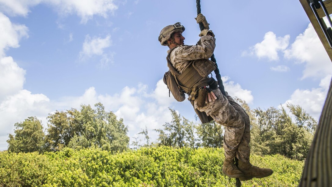 U.S. Marine Lance Cpl. Jose Cortez fast ropes from a tower aboard Marine Corps Base Hawaii, May 12, 2015. Cortez is part of the security element with the 15th Marine Expeditionary Unit’s Maritime Raid Force. These Marines practice fast roping to ensure they are prepared for any type of mission during deployment. (U.S. Marine Corps photo by Cpl. Anna Albrecht/Released)