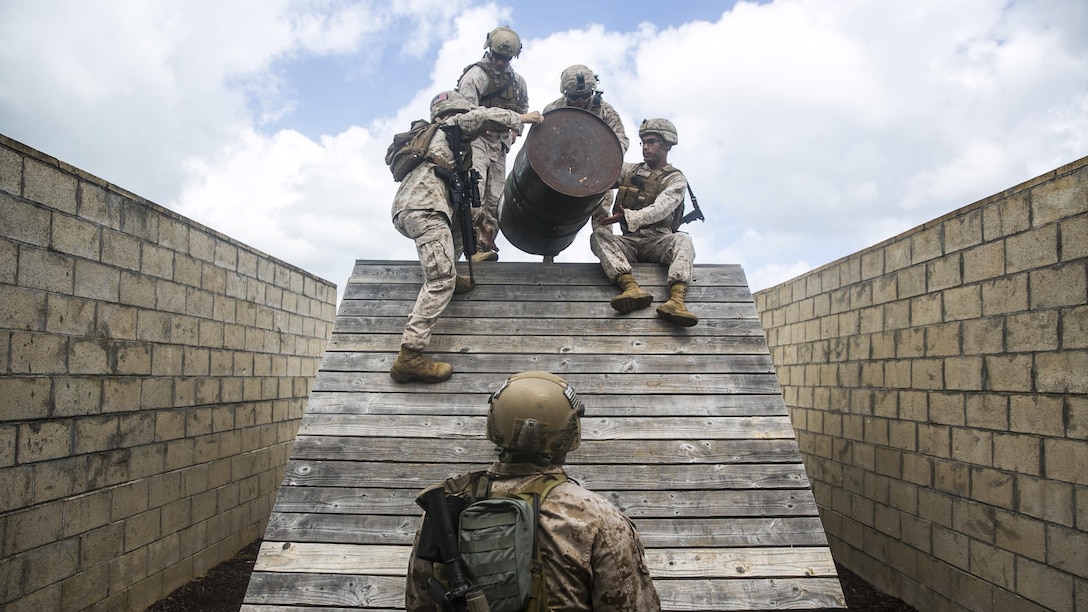 U.S. Marines with the 15th Marine Expeditionary Unit’s Maritime Raid Force participate in a leadership reaction course aboard Marine Corps Base Hawaii, May 18, 2015. In this obstacle, the Marines had to get all personnel, gear, equipment, and the barrel over the bridge without letting the barrel touch the wood. This course is designed to make sure everyone can work as a leader and work with a team. (U.S. Marine Corps photo by Cpl. Anna Albrecht/Released)