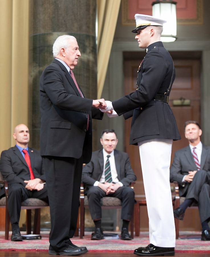 U.S. Navy Capt. Ted Graske (Ret.) presents the Mameluke or Officer’s Sword to Staff Sgt. Patrick Poorbaugh during his commissioning ceremony at the Low Memorial Library Rotunda, Columbia University, New York City, May, 21. Poorbaugh became the first Marine in 40 years to commission from the school. Graske graduated from Columbia in 1959.