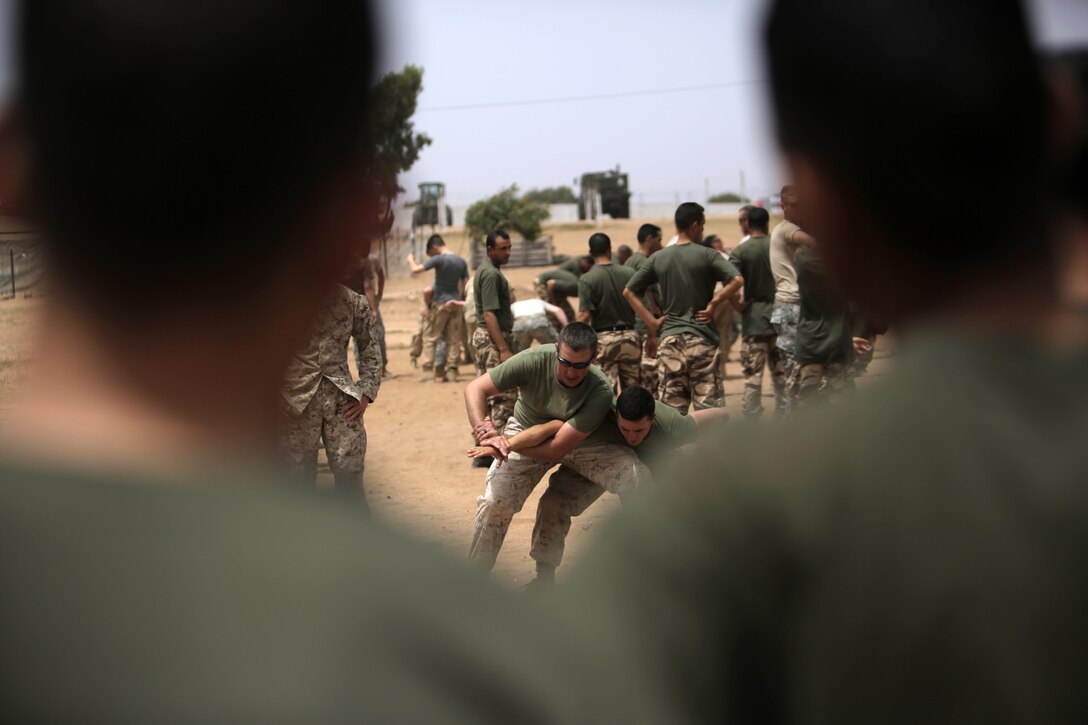 U.S. Marines share their Mechanical Advantage Control Hold (MACH) techniques to Royal Moroccan, U.K., Belgian, and Netherlands Armed Forces during a nonlethal-combative workshop in Tifnit, Morocco, May 15, the stage for Exercise African Lion 15. The international coalition completely integrated, down to the squad level, to build operational familiarity between the Moroccan and NATO service members.