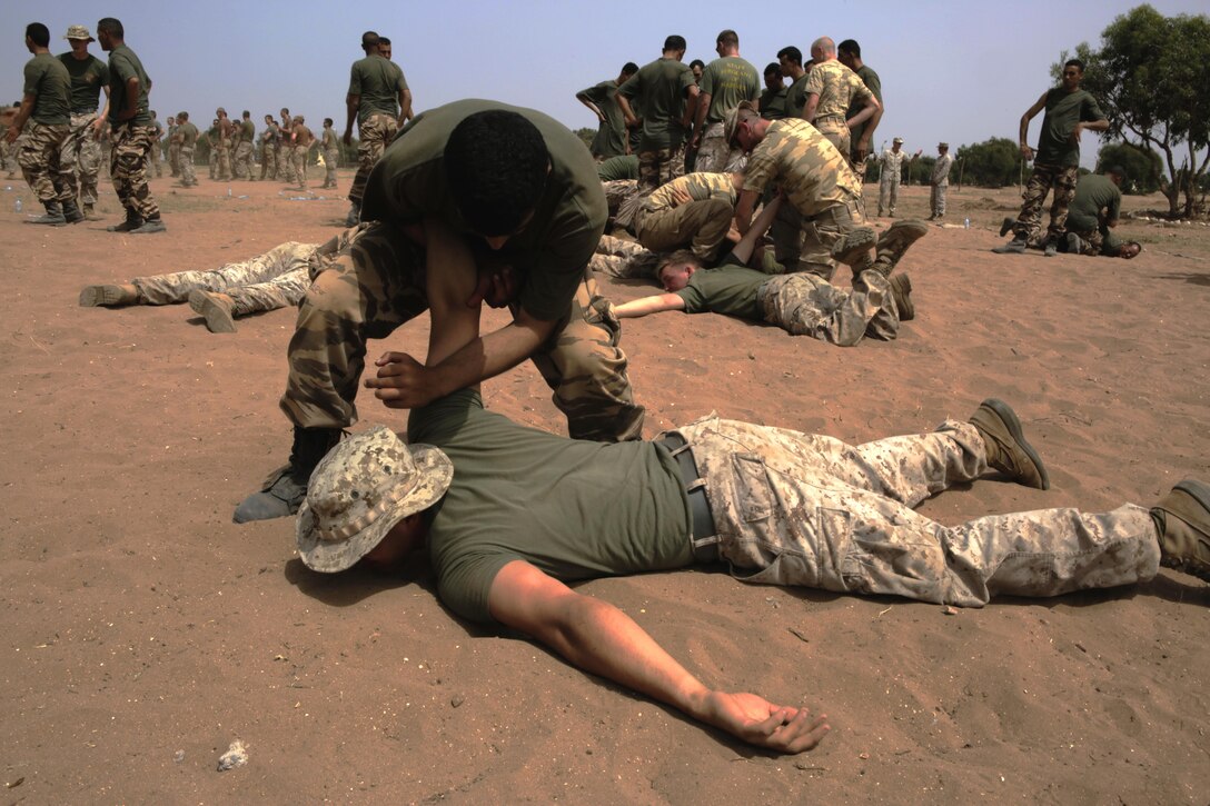 A Royal Moroccan Armed Forces soldier takes down a U.S. Marine while practicing techniques from a nonlethal-combative workshop during Exercise African Lion 15, May 15, in Tifnit, Morocco. The Royal Moroccan, U.S., U.K., Netherlands, and Belgian Armed Forces integrated while conducting peacekeeping support training to improve military capabilities and operational familiarity as one international coalition.