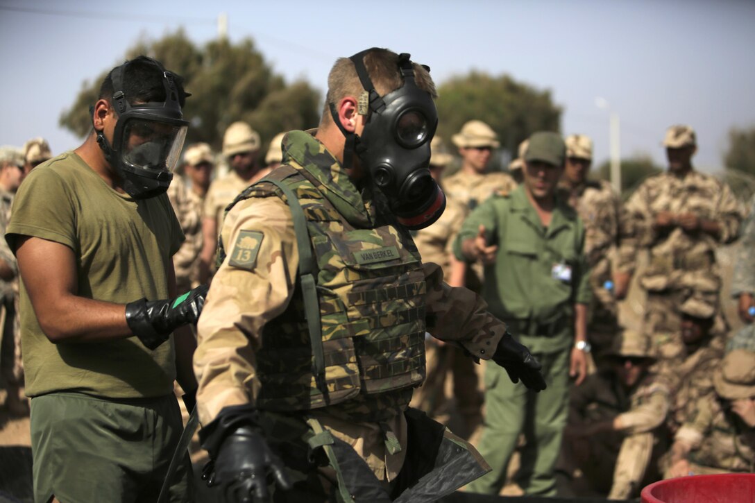 A Royal Moroccan Armed Forces soldier demonstrates a decontamination on Dutch 1st Soldier Peter Van Der Bourght, Netherlands Armed Forces, during a Chemical, Biological, Radiological, and Nuclear defense workshop in Tifnit, Morocco, during Exercise African Lion 15, May 15. This is the first year that CBRN capabilities have been shared by the U.S. Marines to the integrated coalition featuring Moroccan, Netherlands, Belgian and U.S. Army service members.