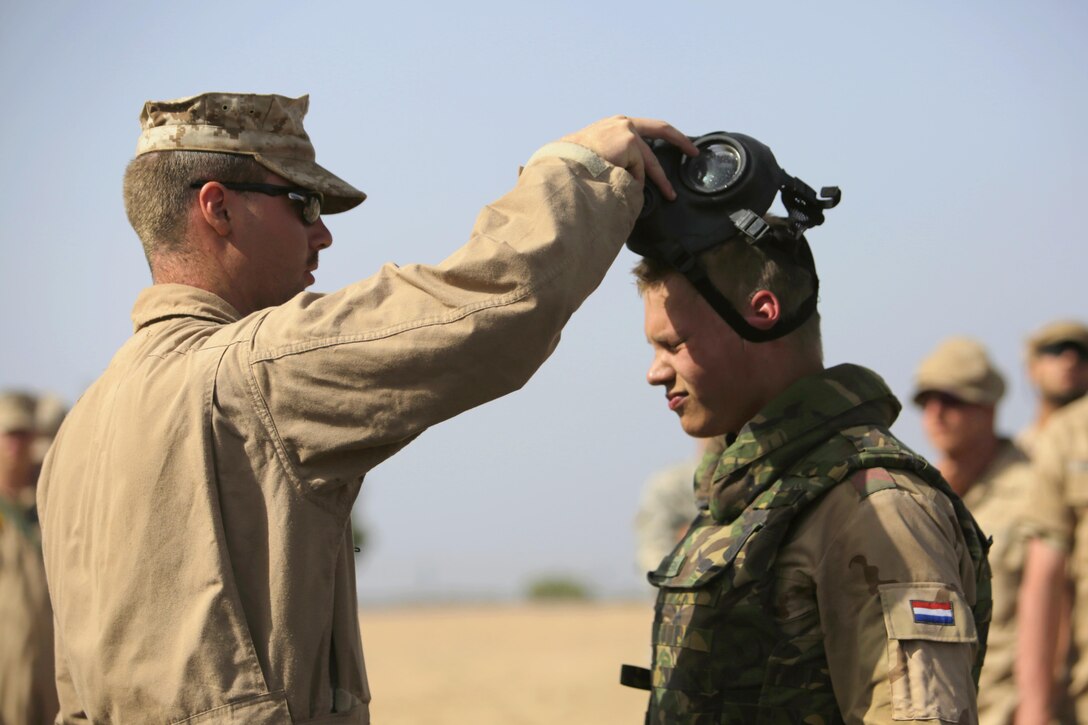 U.S. Marine Corps Cpl. John Lord, Chemical, Biological Incident Response Force, clears Dutch 1st Soldier. Peter Van Der Bourght, Netherlands Armed Forces, after a decontamination exercise, part of the first Chemical, Biological, Radiological, and Nuclear defense workshop ever during Exercise African Lion 15, May 16, in Tifnit, Morocco. Service members from the Moroccan, U.S., U.K., Belgian, and Netherland Armed Forces were completely integrated as one unit to improve military capabilities while working as an international coalition during the exercise.