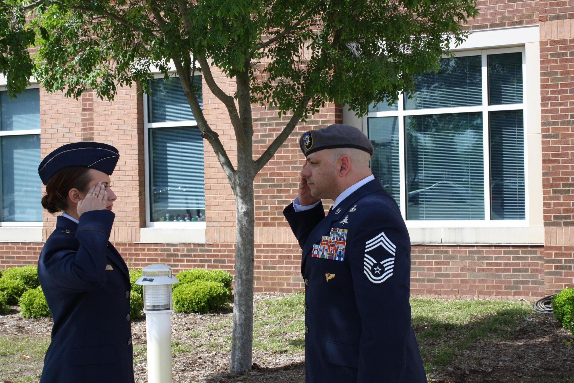 Chief Master Sgt. Jason Colon, 91st Operations Group superintendent, salutes his daughter 2nd Lt. Jenna Colon after her commissioning ceremony at East Carolina University, May 9, 2015. 2nd Lt. Colon is continuing a family tradition of military service that stretches back to the Korean War. (Courtesy photo)
