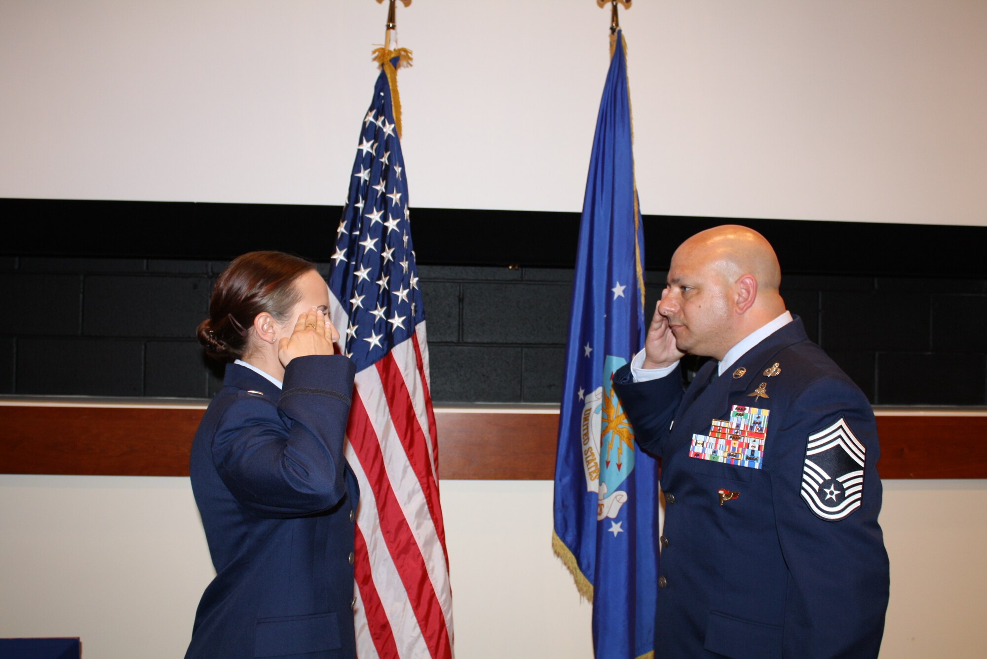 Chief Master Sgt. Jason Colon, 91st Operations Group superintendent, gives his daughter her first salute during her commissioning ceremony at East Carolina University, May 9, 2015. 2nd Lt. Jenna Colon is continuing a family tradition of military service that stretches back to the Korean War. (Courtesy photo)