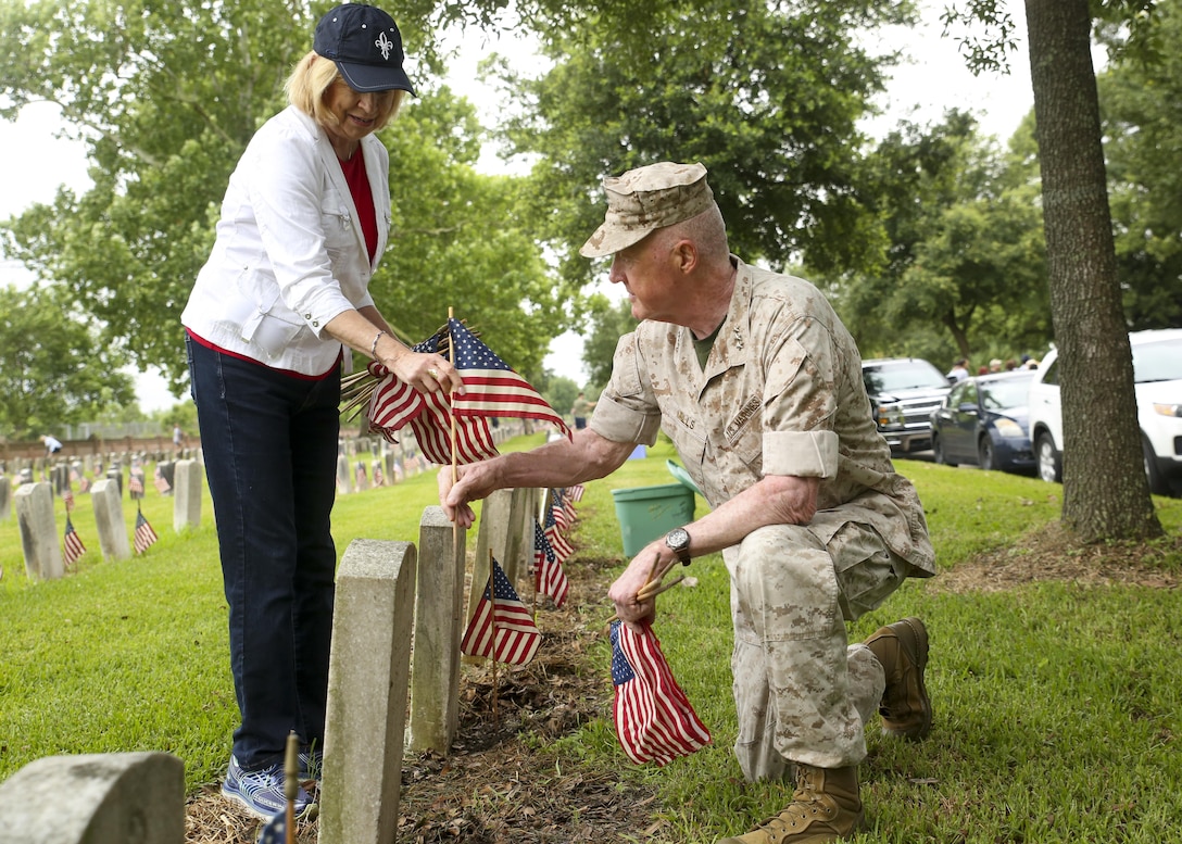 Lt. Gen. Richard P. Mills, commander of Marine Forces Reserve and his wife Patricia place flags at headstones at the Chalmette National Cemetery in Chalmette, La., May 22, 2015. Marines from MARFORRES volunteered Friday morning to place hundreds of flags at headstones in remembrance of Memorial Day to honor the men and women who lost their lives fighting for the country. 