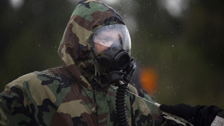 An explosive ordnance disposal technician undergoes the decontamination process after leak, seal, package and decontamination training April 21 at the gas chamber on Camp Hansen, Okinawa. Explosive ordnance disposal technicians and chemical, biological, radiological, nuclear defense specialists placed a leaking ordnance package in the gas chamber, using chlorobenzylidene malonitrile, also known as tear gas, to simulate the emission of harmful gases.