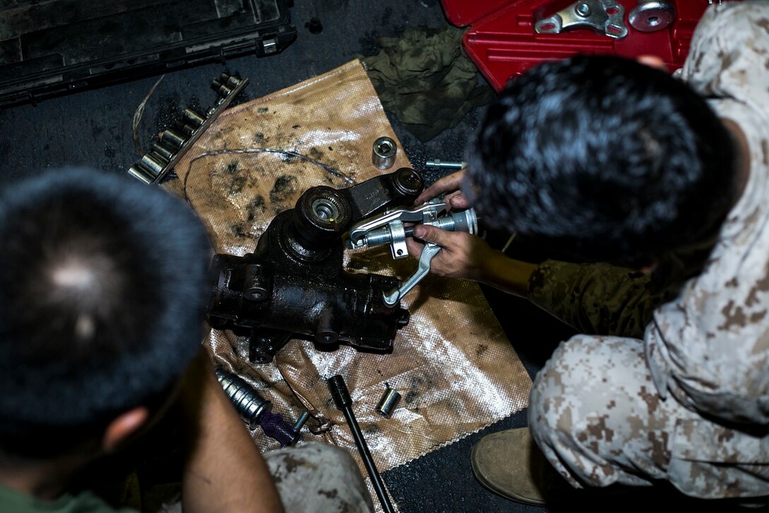 U.S. Marines with Battalion Landing Team 3rd Battalion, 1st Marine Regiment, 15th Marine Expeditionary Unit, conduct routine maintenance on a Humvee aboard the USS Essex (LHD 2) at sea in the Pacific Ocean, May 24, 2015. Ensuring all equipment is in good condition is essential to the MEU’s combat readiness. (U.S. Marine Corps photo by Cpl. Anna Albrecht/ Released)
