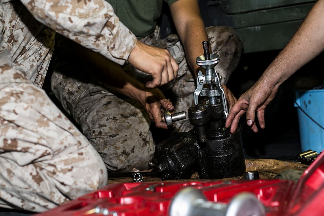 U.S. Marines with Battalion Landing Team, 3rd Battalion, 1st Marine Regiment, 15th Marine Expeditionary Unit, conduct routine maintenance on a Humvee aboard the USS Essex (LHD 2) at sea in the Pacific Ocean, May 24, 2015. These Marines work on their equipment daily to ensure they are constantly combat ready. (U.S. Marine Corps photo by Cpl. Anna Albrecht/ Released)