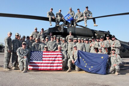 Alaska Army National Guardmembers from B Company, 1-207th Aviation, pose for a group photo next to a UH-60 Black Hawk helicopter in Iraq. The Alaska Guardsmen or “Arctic Cowboys” transport distinguished visitors, Soldiers and equipment from camp to camp, ensuring their safety and assisting in the completion of valuable missions.