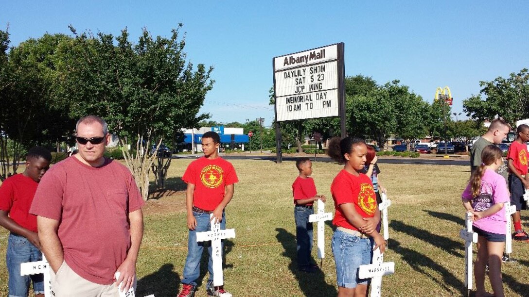 The Young Marines of Albany, Georgia, volunteer their time, May 23, to place flags and crosses in front of the Albany Mall to commemorate fallen service members.
