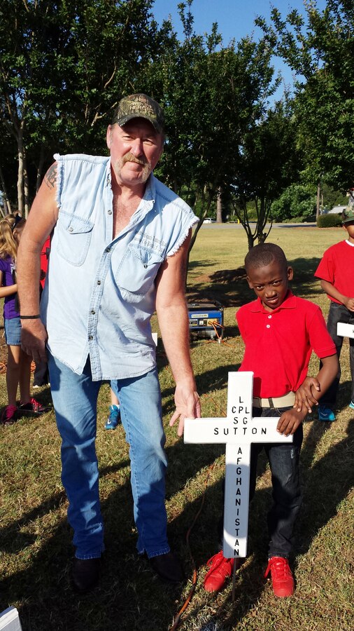 Private Jordan Pickett, Young Marines OF Albany, Ga., and Gene Sutton place a cross in memory of his son in the field outside of the Albany Mall, May 23.  Fallen Marine Lance Cpl. Steven Sutton, Leesburg, Ga., lost his life in the line of duty, while conducting combat operations in Helmand Province, Afghanistan, May 26, 2012.
