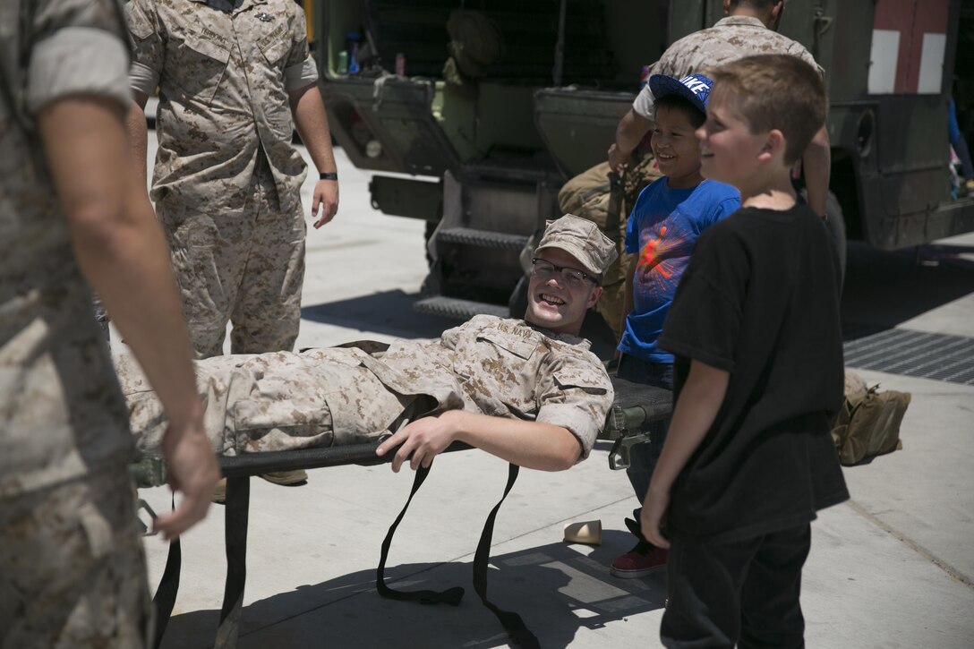 Palm Vista Elementary School students lift a stretcher with Seaman Sean Sullivan, field medical service technician, 1st Tank Battalion, on it during a tour of the 1st Tanks Tank Ramp, May 18, 2015. During the tour, the students had the opportunity to see four M1A1 Abrams, an M88A2 Hercules, an ambulance, a Medium Tactical Vehicle Replacement, a Mine Resistant Ambush Protected All-Terrain Vehicle and a Logistics Vehicle System Replacement. (Official Marine Corps photo by Lance Cpl. Thomas Mudd/ Released)