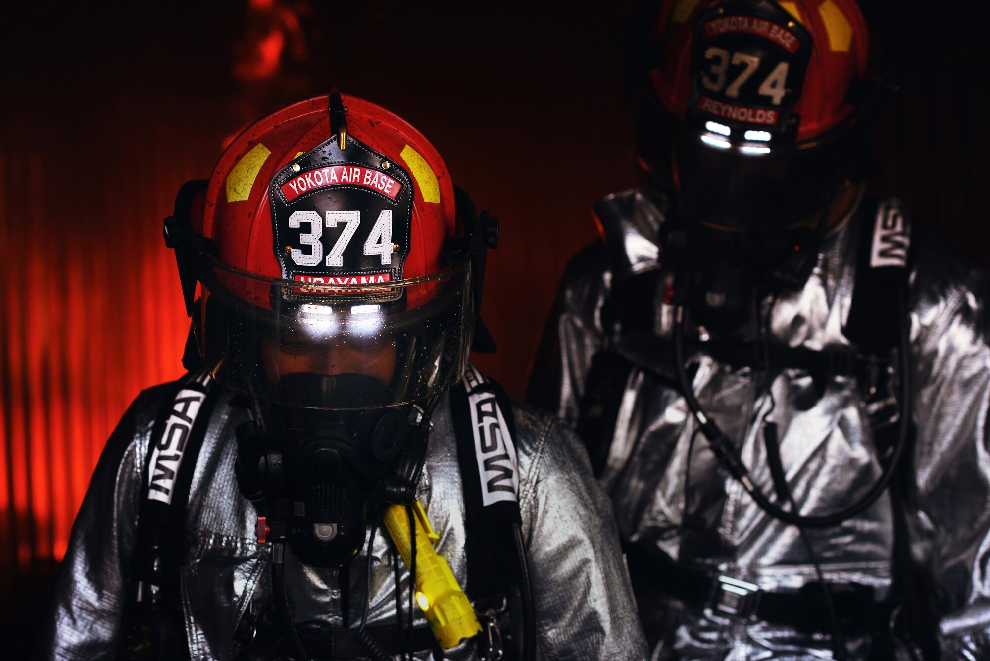 Akira Urayama, left, and Staff Sgt. Joshua Reynolds, right, both 374th Civil Engineer Squadron firefighters, help to put out a fire during a joint fire training scenario May 26, 2015, at Yokota Air Base, Japan. "All day, every day, we train," said Reynolds. (U.S. Air Force photo by Airman 1st Class Delano Scott/Released)