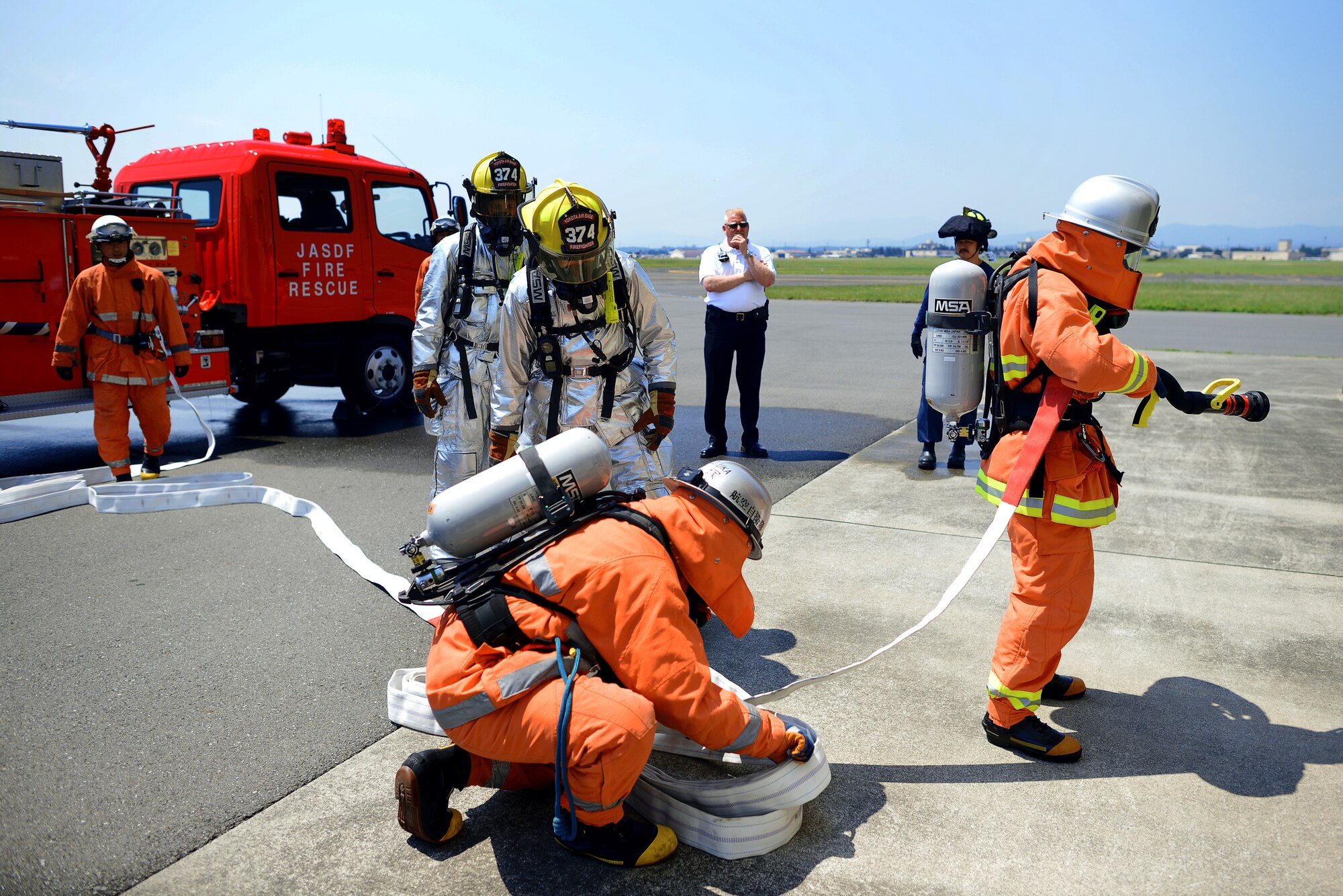 Firefighters from the 374th Civil Engineer Squadron and Japan Air Self-Defense Force prepare to enter a fire training facility May 26, 2015, at Yokota Air Base, Japan. This bilateral training opportunity ensured that the 374 CES and JASDF firemen are able to work in sync with one another if they should have to emergencies on base. (U.S. Air Force photo by Airman 1st Class Delano Scott/Released)