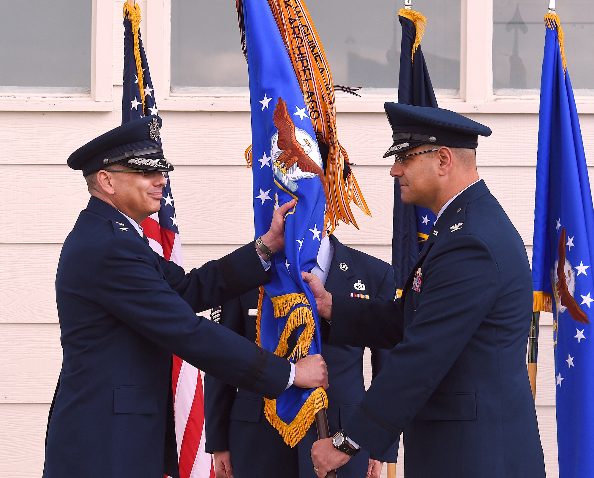 Maj. Gen. Jack Weinstein, 20th  Air Force and Task Force 214 commander, presents Col. Stephen M. Kravitsky the 90th  Missile Wing guidon as Kravitsky assumed command of the wing during a ceremony on F.E. Warren Air Force Base, Wyo., May 27, 2015. (U.S. Air Force photo by R.J. Oriez) 