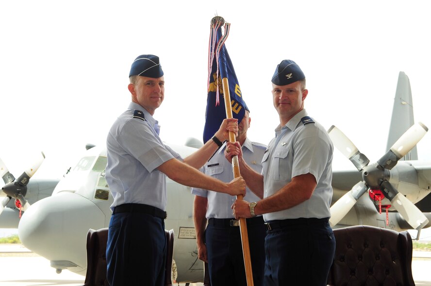 U.S. Air Force Brig. Gen. Gregory Guillot, 55th Wing commander hands the unit guidon to Col. Ryan Rogers as he takes command of the 55th Electronic Combat Group at Davis-Monthan Air Force Base, Ariz., May 27, 2015. The  55th ECG commander is responsible for five squadrons of more than 700 Airmen to provide combat-ready EC-130H Compass Call aircraft, aircrew and maintainers for worldwide expeditionary deployment in support of unified combatant commanders. (U.S. Air Force photo by Airman 1st Class Chris Massey/Released)