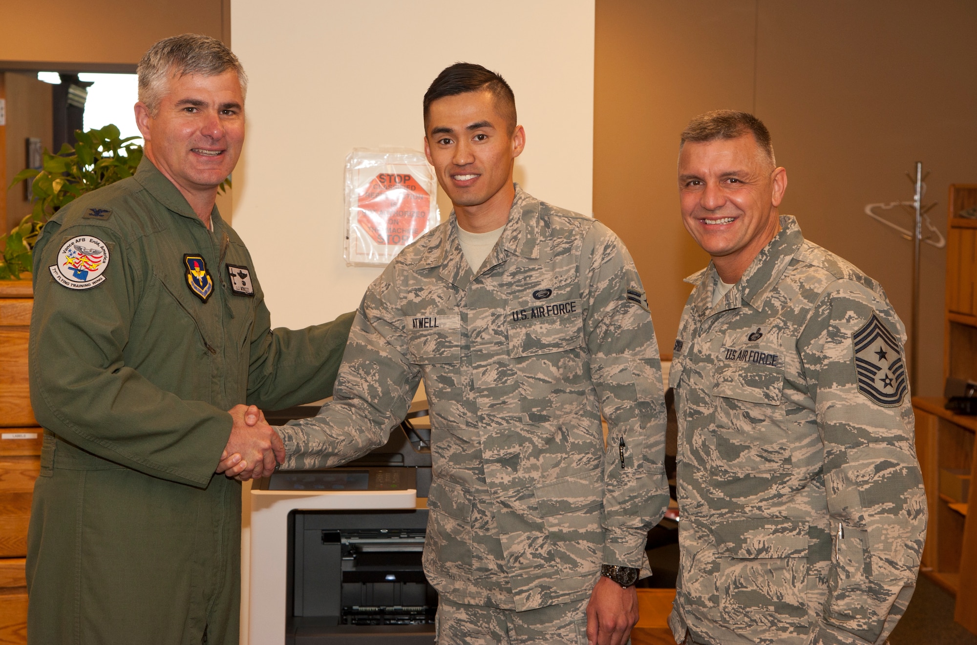 Airman 1st Class James Atwell, a 71st Force Support Squadron force management journeyman, receives a 71st Flying Training Wing commander’s coin from Col. John Menozzi, the 71st FTW vice commander, May 11 at Vance Air Force Base, Oklahoma and Chief Master Sgt. Peter Speen, the 71st FTW command chief. Menozzi and Col. Christopher Daniels, the 71st Mission Support Group commander, recognized Atwell as the 71st FTW Airman of the Month for May. (U.S. Air Force photo / Tech. Sgt. James Bolinger)