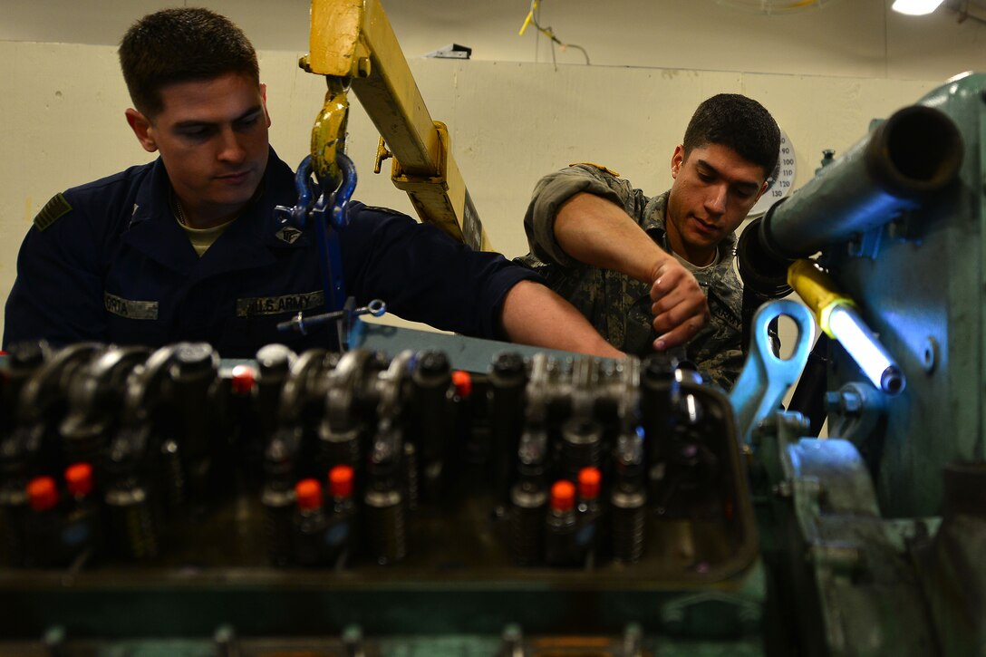 U.S. Army Second Staff and Faculty Watercraft Engineer Certification Course students Sgt. Benjamin Acevado,right, and Sgt. Adrian Orta, tighten bolts during an engine rebuild at Fort Eustis, Va., May 21, 2015. While tightening bolts, students must also check the torque value of each to ensure they reach and do not exceed an exact pressure. (U.S. Air Force photo by Staff Sgt. Natasha Stannard/Released)