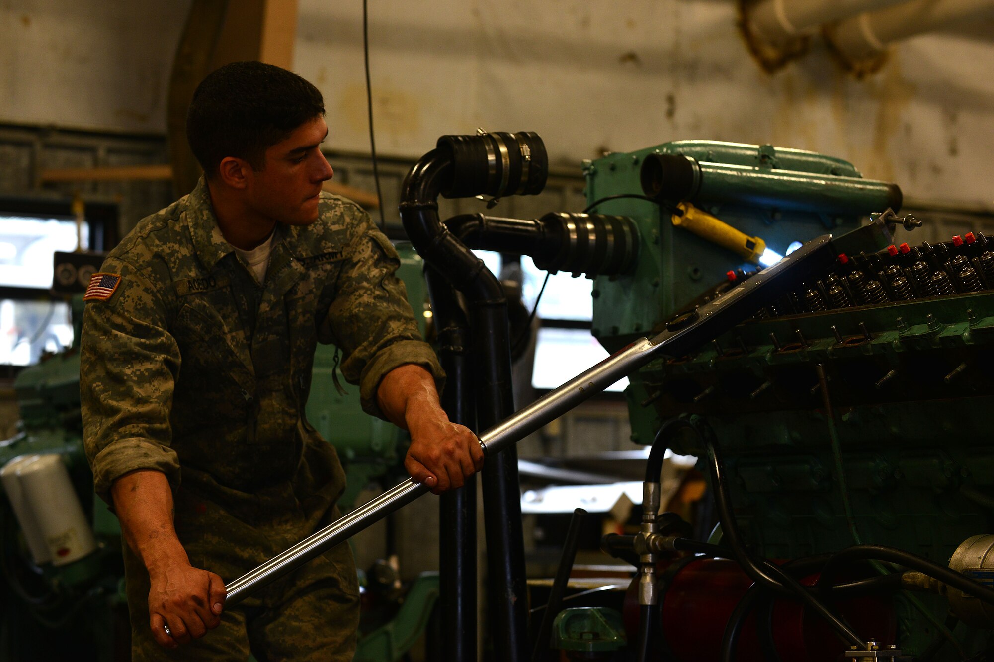 U.S. Army Sgt. Benjamin Acevado, 2nd Staff and Faculty Company Watercraft Engineer Certification Course student, tightens a locknut during an engine rebuild at Fort Eustis, Va., May 21, 2015. During the engine rebuild, students learn the steps of repairing and maintaining a diesel engine for any Army vessel. (U.S. Air Force photo by Staff Sgt. Natasha Stannard/Released)